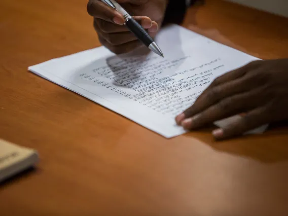 Close up of hands writing on a sheet of paper