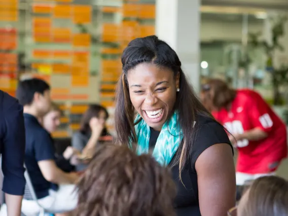 Black student smiling while conversing with friends